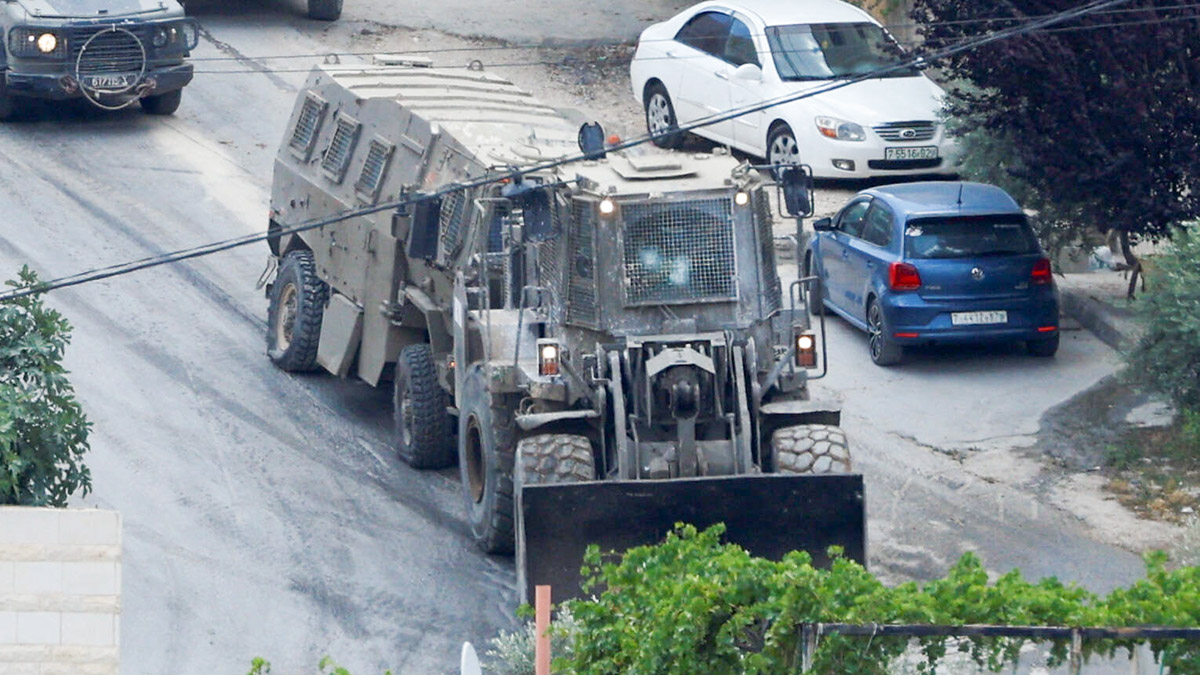 An Israeli military vehicle damaged during clashes with Palestinian gunmen is towed by a machinery during an Israeli raid in Jenin, in the Israeli-occupied West Bank June 19, 2023. REUTERS/Mohamad Torokman