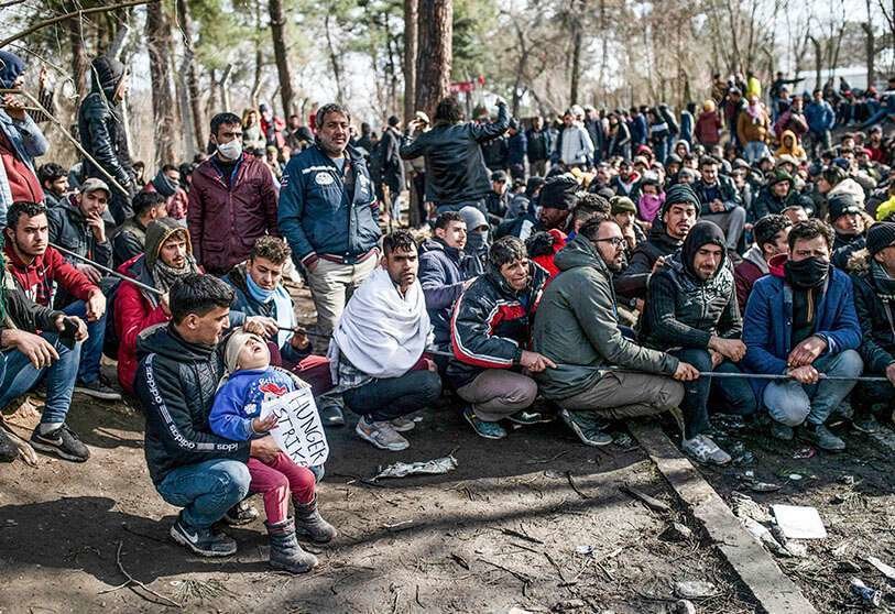 AFP/ BULENT KILIC - Los migrantes esperan en la zona de amortiguación de la frontera entre Turquía y Grecia, cerca del paso fronterizo de Pazarkule en Edirne, el 5 de marzo de 2020