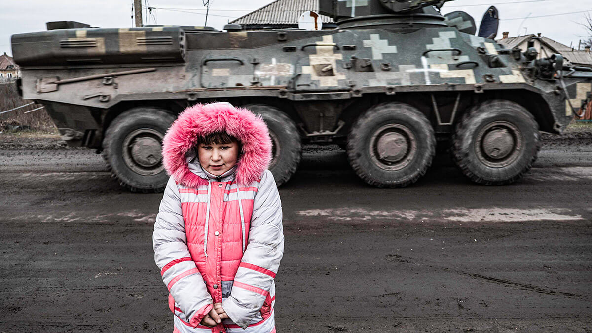 Lisa Shtanko, de 8 años, observa cómo un vehículo militar pasa frente a su casa en la ciudad de Lyman, al este de Ucrania, el 23 de diciembre de 2022
AFP/IONUT IORDACHESCU