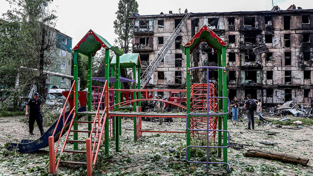Parque infantil frente a un edificio residencial destruido tras un ataque ruso, en la ciudad de Kryvyi Rig el 13 de junio de 2023
AFP/STAS YURCHENKO