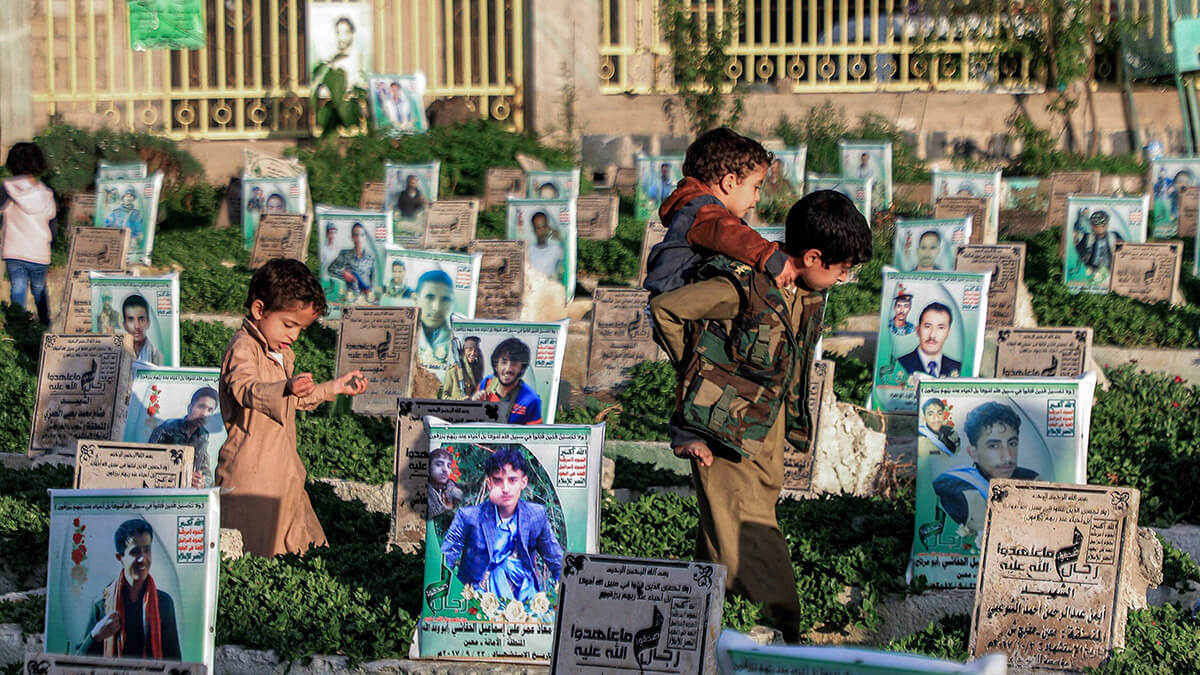 AFP/ MOHAMMED HUWAIS - Niños caminan entre las tumbas de las personas que presuntamente murieron durante la guerra en Yemen en un cementerio en la capital Huthi, Sanaa, el 14 de abril de 2023 durante el mes sagrado musulmán del Ramadán