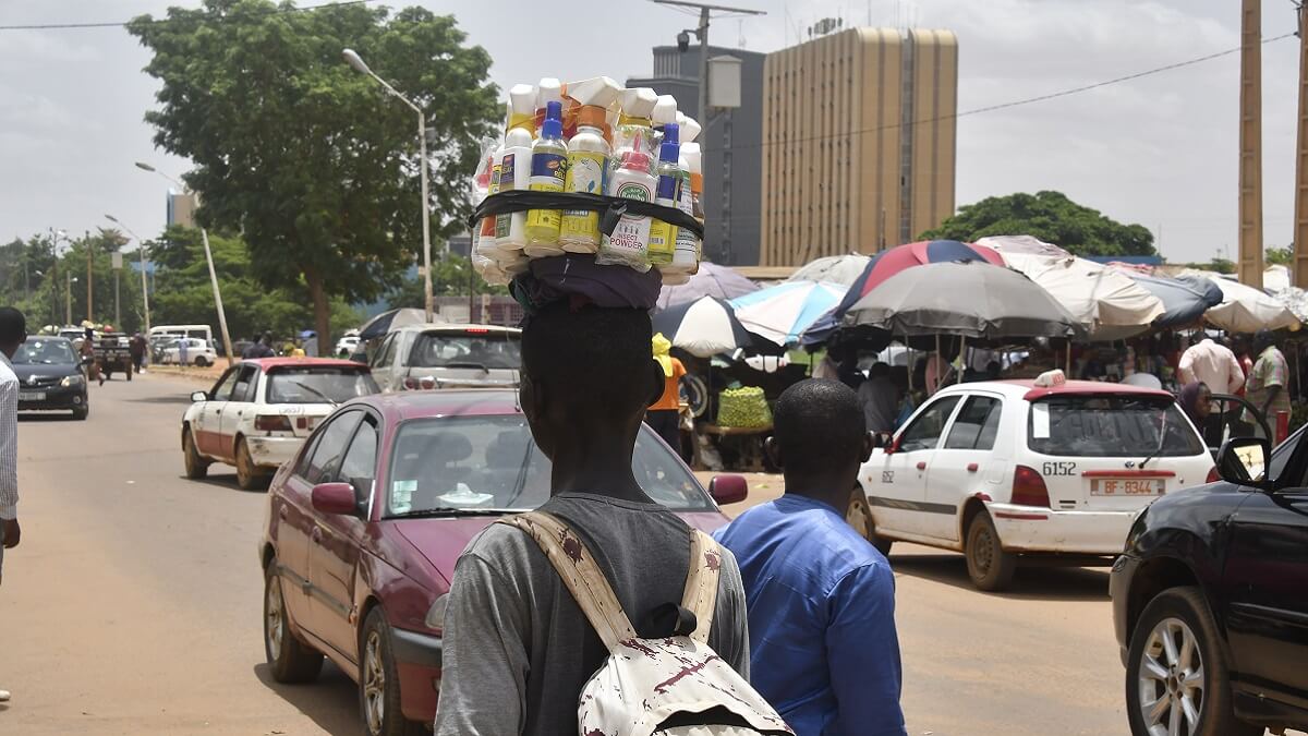 PHOTO/AFP/BOUREIMA HAMA - Un vendedor ambulante camina junto a una calle que parece tranquila con tráfico normal en Niamey el 26 de julio de 2023 mientras el presidente nigeriano Mohamed Bazoum es retenido por guardias según una fuente cercana a Bazoum