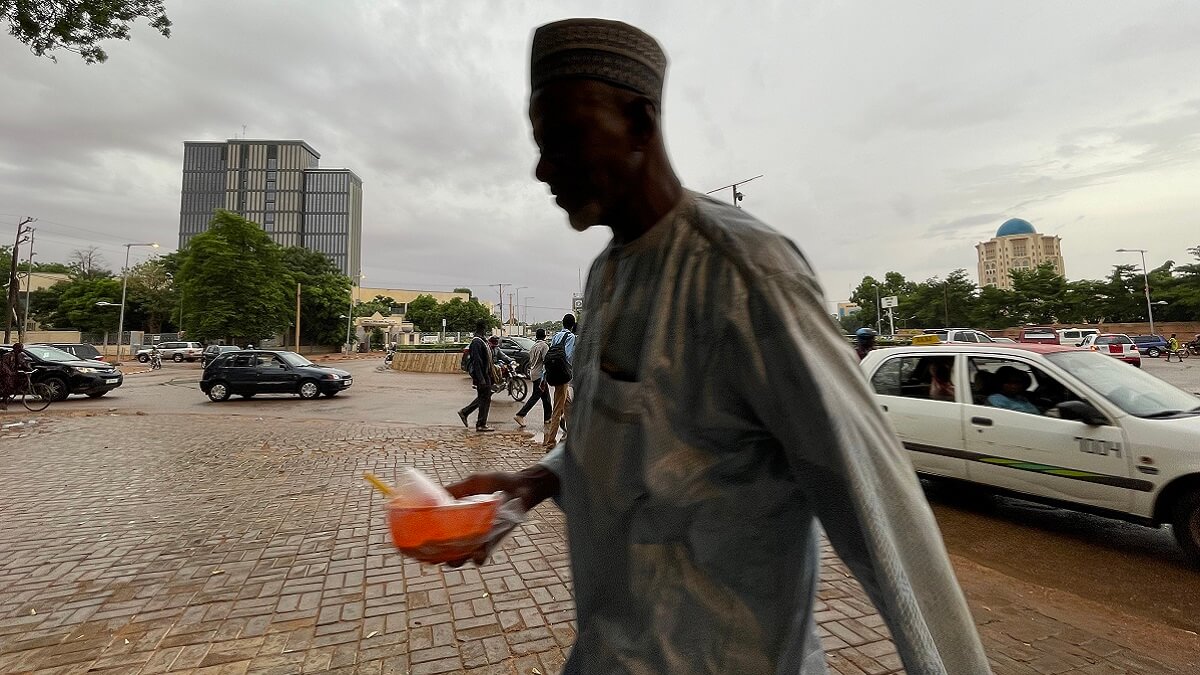 PHOTO/AFP - Un hombre camina por la acera en Niamey el 27 de julio de 2023 después de que el presidente de Níger, Mohamed Bazoum, fuera detenido por tropas de élite que declararon haber tomado el poder en la conflictiva nación de África occidental