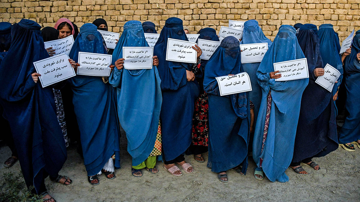 Mujeres afganas vestidas con burka sostienen pancartas mientras protestan por su derecho a la educación, en Mazar-i-Sharif el 12 de agosto de 2023
AFP/ATEF ARYAN