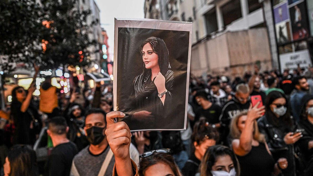 Una manifestante sostiene un retrato de Mahsa Amini durante una manifestación - AFP/OZAN KOSE