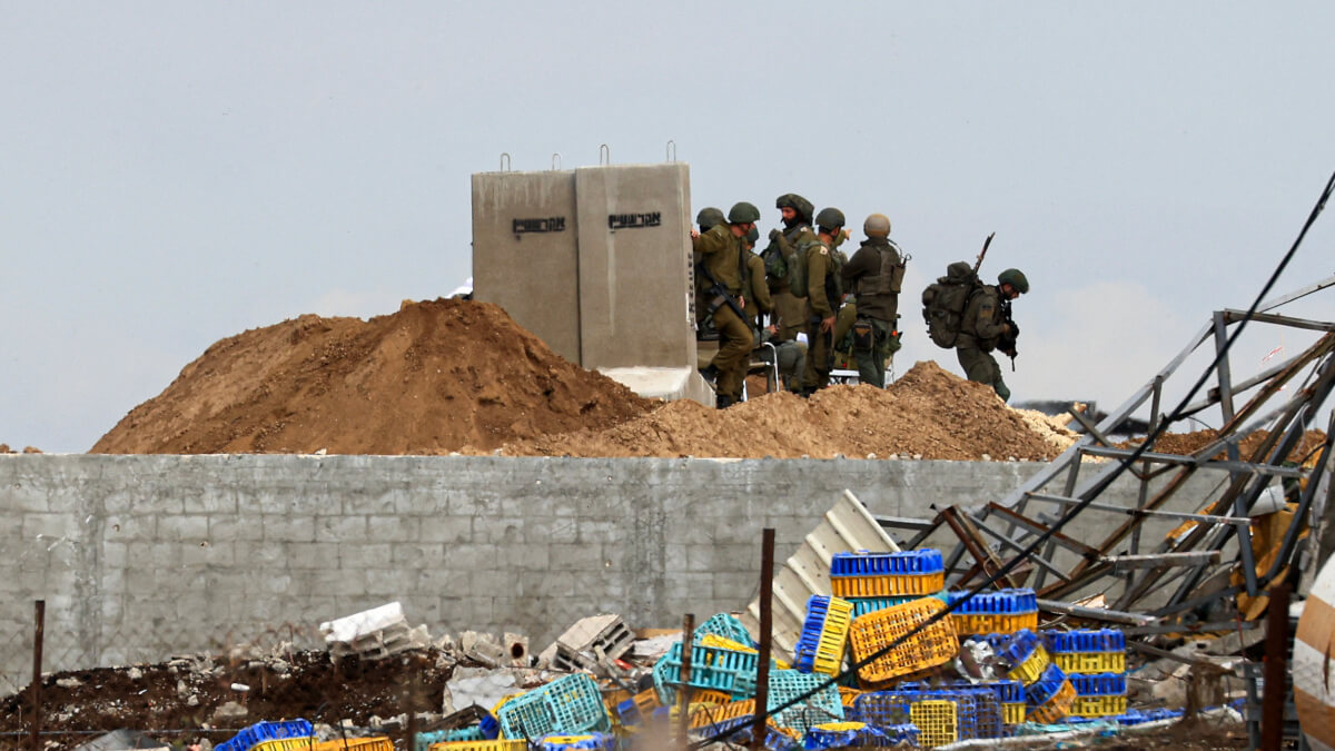 MAHMUD HAMS / AFP - Las tropas israelíes toman posiciones en una elevación que domina la carretera de Salaheddine que une el norte de la Franja de Gaza con el sur en el distrito de Zeitoun en las afueras de la ciudad de Gaza el 28 de noviembre de 2023