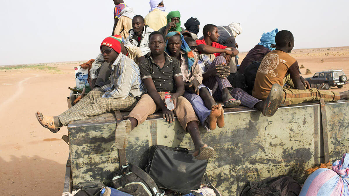 REUTERS/JOE PENNEY - Migrantes nigerinos, que viajan hacia el norte en dirección a Libia, viajan encima de un camión en Agadez