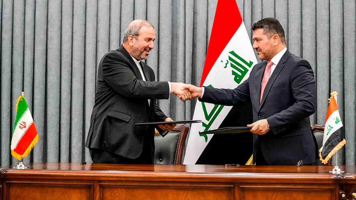 AFP/OFICINA DE PRENSA DE LOS PRIMEROS MINISTROS IRAQUÍES - El jefe de gabinete del Primer Ministro, Ihsan al-Awadi (R), y al embajador de Irán en Bagdad, Mohammad Kazem al-Sadeq, dándose la mano mientras intercambian firmó acuerdos bilaterales durante una ceremonia en Bagdad el 11 de julio de 2023