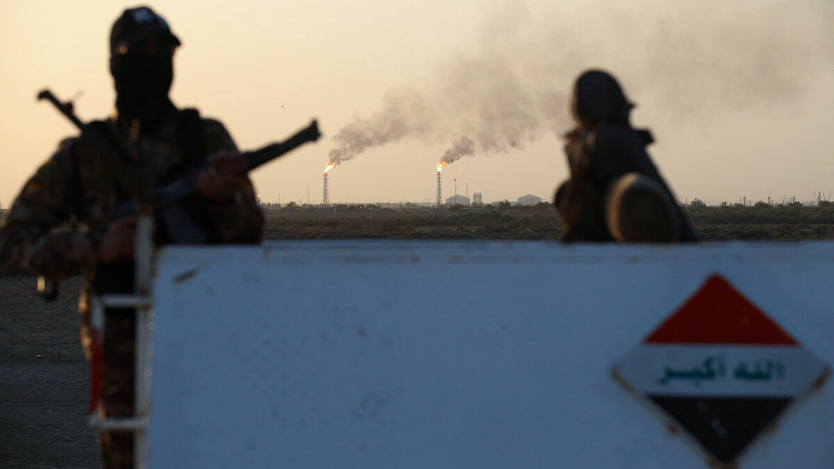 AFP/AHMAD AL-RUBAYE - Policías iraquíes hacen guardia en el campo petrolífero de Halfaya, perteneciente a la empresa PetroChina, en el distrito de al-Kahla, en la ciudad de Amara, al sur de Bagdad, el 26 de julio de 2022