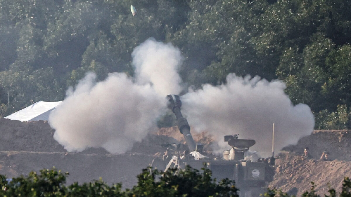 Una imagen tomada desde el sur de Israel, cerca de la frontera con la Franja de Gaza, el 4 de diciembre de 2023, muestra un tanque israelí disparando hacia el territorio palestino en medio de los continuos combates entre Israel y el grupo militante Hamás - PHOTO/AFP/JACK GUEZ