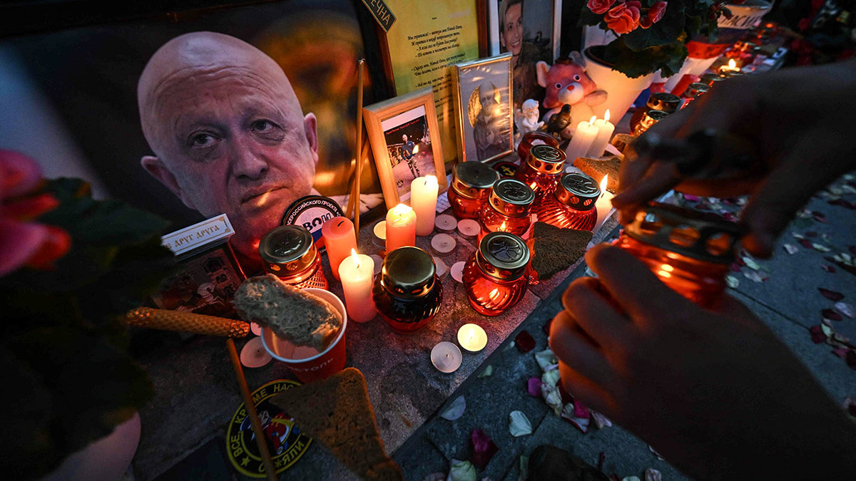 Un hombre enciende una vela en un monumento improvisado al jefe del grupo mercenario privado Wagner, Yevgeny Prigozhin - AFP/ NATALIA KOLESNIKOVA