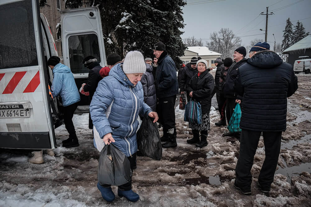 Los vecinos de Sviatorhirsk, donde hoy sólo quedan un 10 por ciento de sus residentes, recogiendo ayuda humanitaria - PHOTO/MARIA SENOVILLA