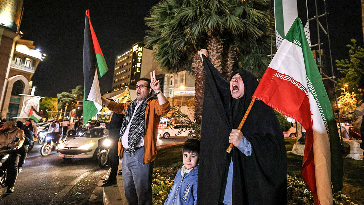 Manifestantes ondean la bandera iraní y las banderas palestinas mientras se reúnen en la Plaza Palestina en Teherán el 14 de abril de 2024, después de que Irán lanzara un ataque con aviones no tripulados y misiles contra Israel - AFP/ATTA KENARE