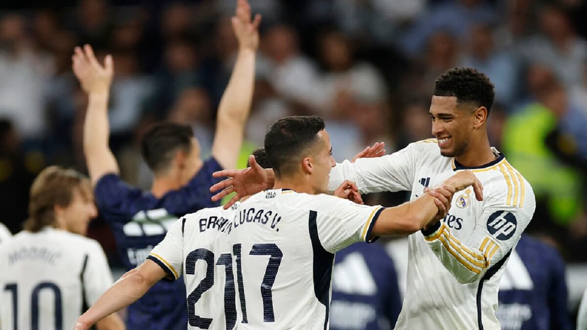 El centrocampista inglés del Real Madrid Jude Bellingham y el defensa español del Real Madrid Lucas Vázquez celebran su victoria al final del partido de fútbol de la Liga española entre el Real Madrid CF y el FC Barcelona en el estadio Santiago Bernabéu de Madrid el 21 de abril de 2024 – PHOTO/ÓSCAR DEL POZO/AFP
