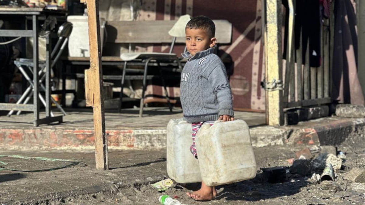 Un niño transporta bidones de agua en la Franja de Gaza - © UNRWA