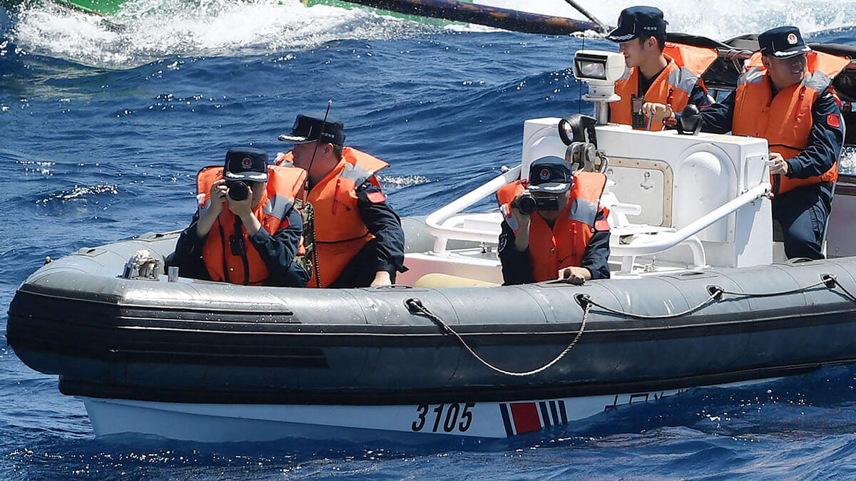 Guardia costera china a bordo de su barco de casco rígido usando cámaras fijas y de video para registrar la actividad a bordo del barco BRP Datu Tamblot de la Oficina de Pesca y Recursos Acuáticos de Filipinas (BFAR) cerca del Scarborough Shoal, controlado por China, en aguas en disputa del Mar de China Meridional - AFP/TED ALIBE