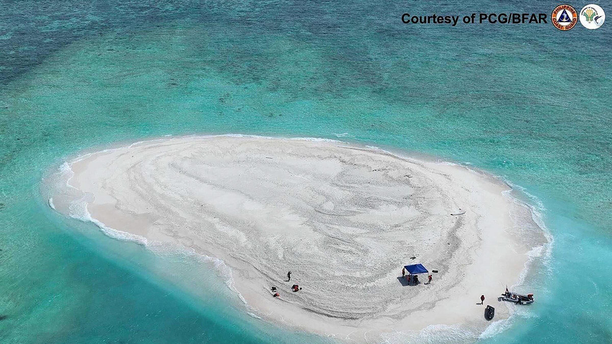 Científicos filipinos inspeccionando el arrecife Sandy Cay, en las islas Spratly, en el disputado Mar de China Meridional - AFP/GUARDIA COSTERA DE FILIPINA/Oficina de PESCA Y RECURSOS ACUÁTICOS (PCG/BFAR)