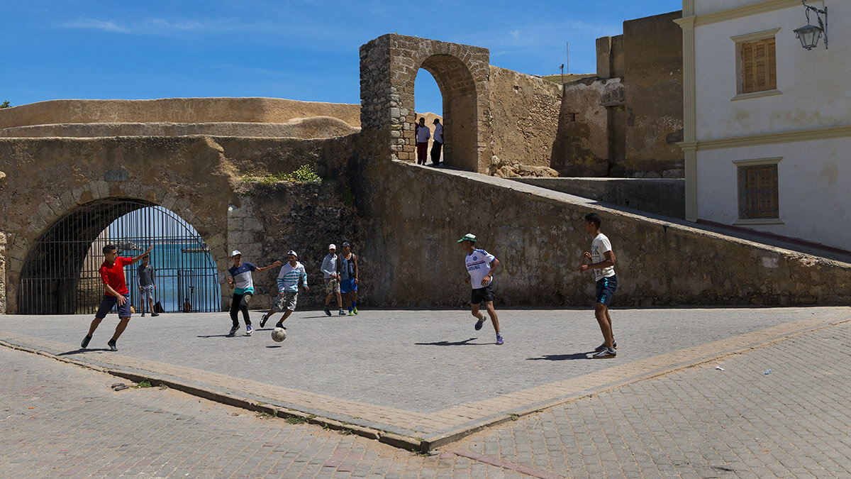 Jóvenes jugando al fútbol en una plaza en la ciudad de El Jadida en la costa atlántica de Marruecos - <a target="_blank" data-cke-saved-href="https://depositphotos.com/es/?/" href="https://depositphotos.com/es/?/">Depositphotos</a>
