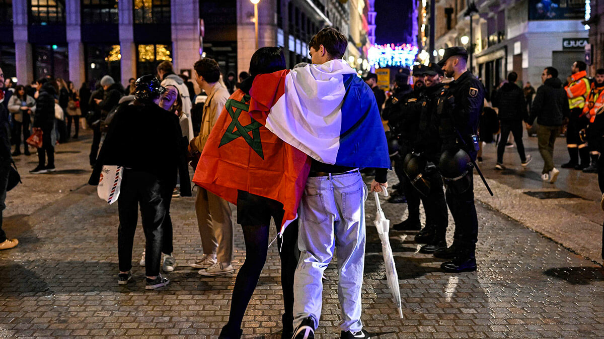 Pareja envuelta en las banderas de Marruecos y Francia después del partido de fútbol de semifinales de la Copa del Mundo Qatar 2022 entre Francia y Marruecos el 14 de diciembre de 2022 - AFP/OSCAR DEL POZO