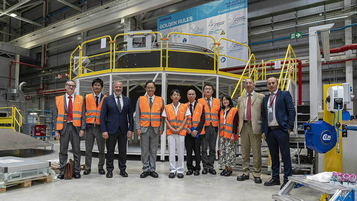 La delegación nipona presidida por el embajador Takahiro Nakamae posa delante de uno de los adaptadores de carga diseñados y construidos en Getafe para el nuevo lanzador japonés H3 - PHOTO/Airbus DS
