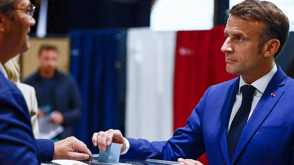 El presidente de Francia, Emmanuel Macron (der.), emite su voto en la primera vuelta de las elecciones - AFP/YARA NARDI