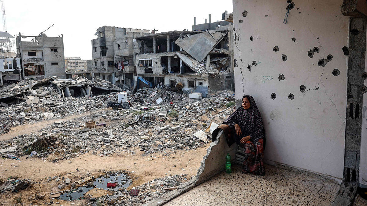 <p>Una mujer palestina se sienta en los restos de su casa dañada en un bombardeo israelí anterior, mientras algunos residentes regresan a la ciudad de Khan Yunis, en el sur de la Franja de Gaza, el 30 de junio de 2024 - AFP/EYAD BABA</p>