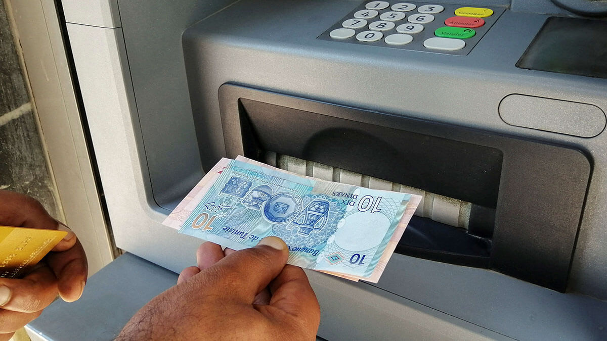Un hombre muestra billetes de dinares tunecinos después de retirar efectivo de un cajero automático en Túnez - REUTERS/JIHED ABIDELLAOUI