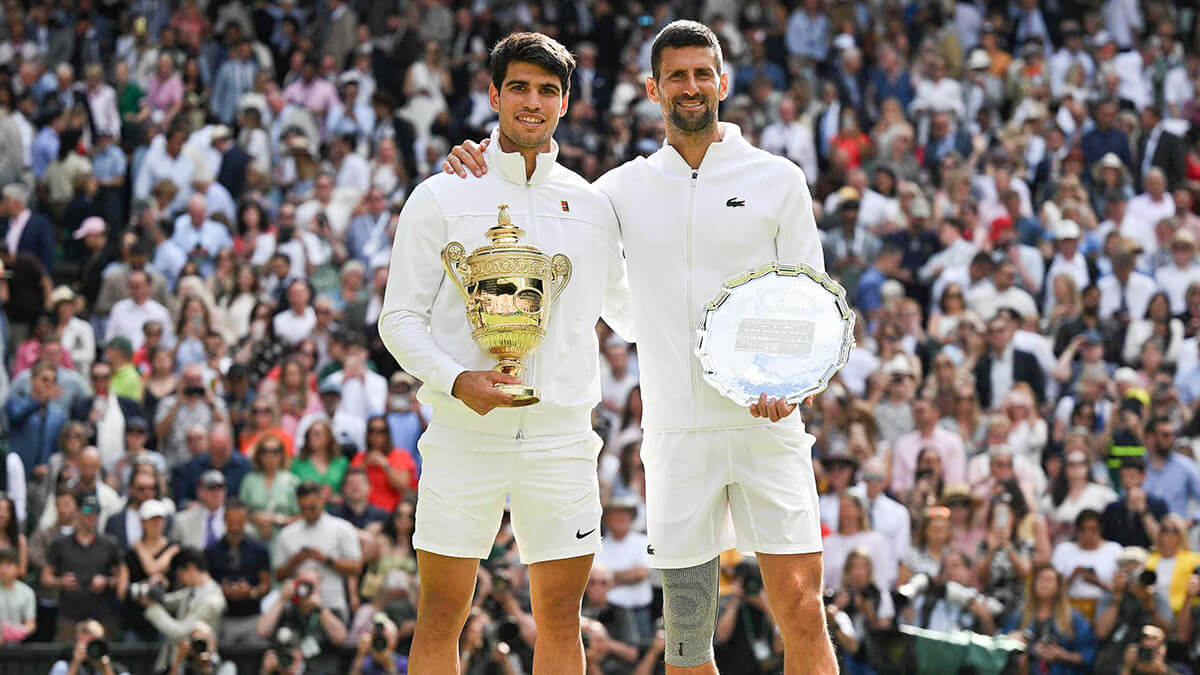 <p>El español Carlos Alcaraz sostiene el trofeo de campeón y el serbio Novak Djokovic, segundo clasificado, posan para fotografías durante la ceremonia de premios al final de su partido final de tenis individual masculino en el decimocuarto día del Campeonato de Wimbledon 2024 en el All England Lawn Tennis and Croquet Club en Wimbledon, el 14 de julio de 2024 - AFP/ANDREJ ISAKOVIC </p>