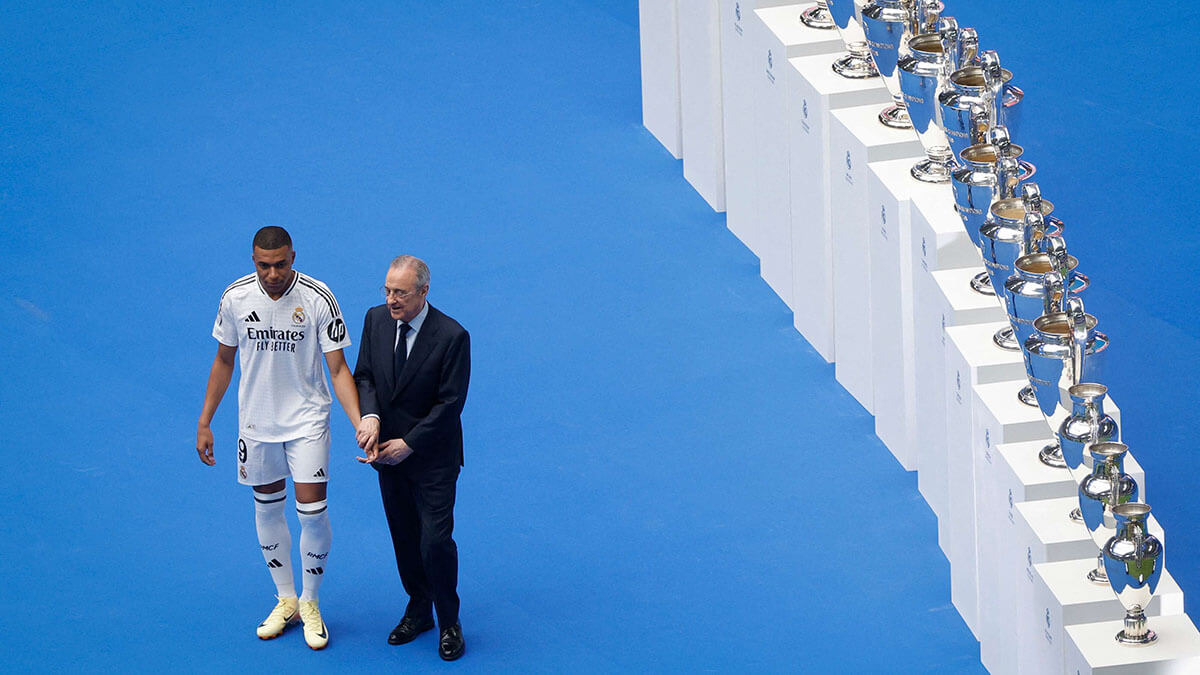 <p>El delantero francés Kylian Mbappé (izq.) posa con el presidente del Real Madrid, Florentino Pérez, durante su primera aparición como jugador del Real Madrid en el Estadio Santiago Bernabéu de Madrid el 16 de julio de 2024, tras firmar su nuevo contrato de cinco temporadas - AFP/OSCAR DEL POZO </p>