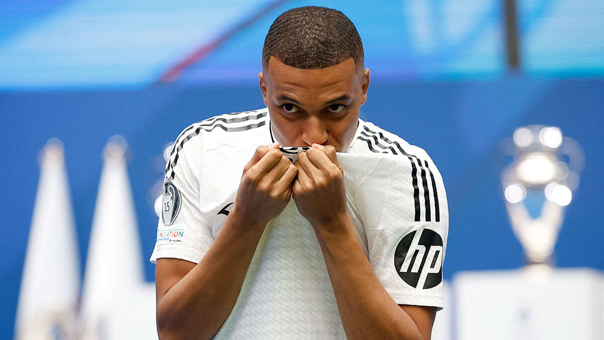 <p>El nuevo fichaje del Real Madrid, Kylian Mbappé, besa el escudo del club durante la presentación - REUTERS/JUAN MEDINA </p>