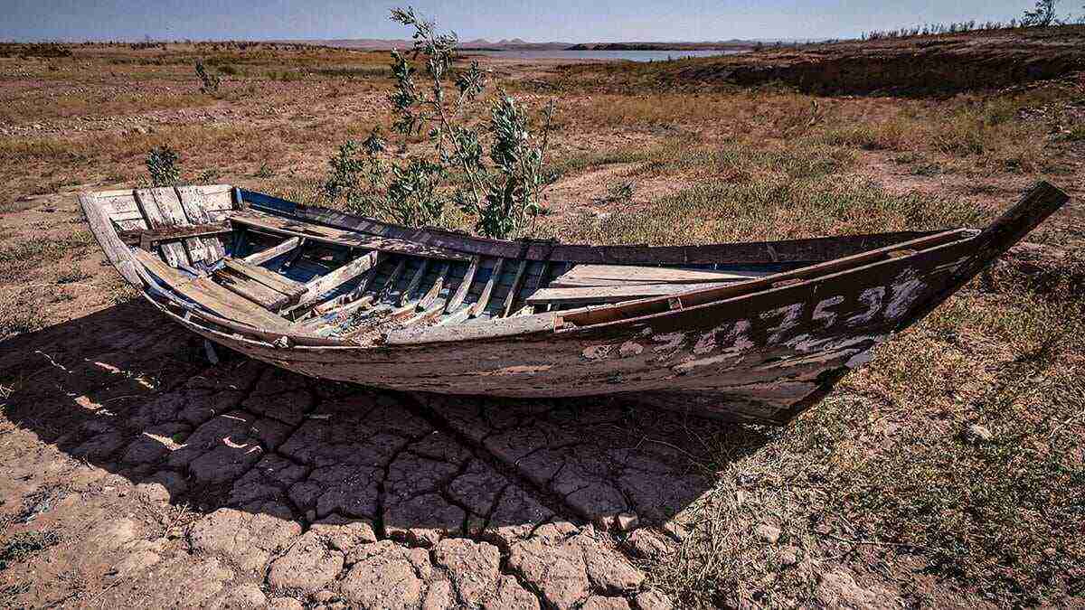 Una embarcación se encuentra sobre tierra agrietada en la presa de al-Massira en la aldea de Ouled Essi Masseoud, a unos 140 kilómetros (85 millas) al sur de la capital económica de Marruecos, Casablanca, el 8 de agosto de 2022 en medio de la peor sequía del país en al menos cuatro décadas - AFP/FADEL SENNA