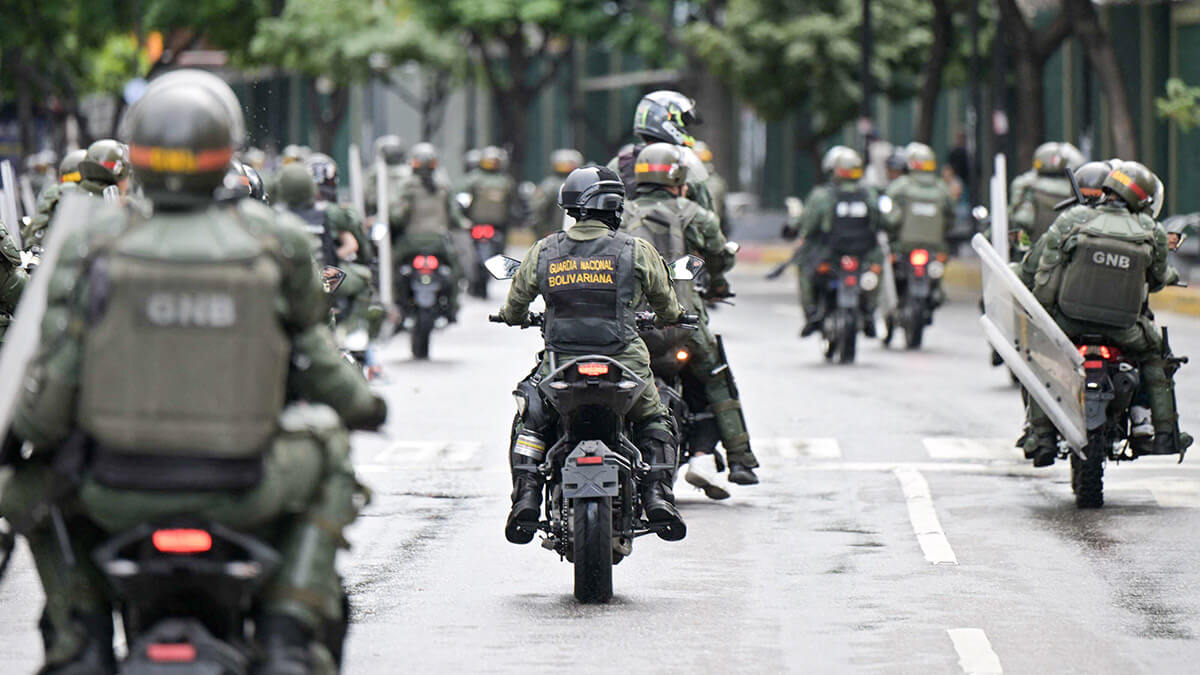 <p>Miembros del escuadrón antidisturbios de la Guardia Nacional Bolivariana (GNB) avanzan en el barrio de Chacao mientras opositores al presidente venezolano Nicolás Maduro participan en una manifestación, en Caracas el 30 de julio de 2024 - AFP/YURI CORTEZ</p>