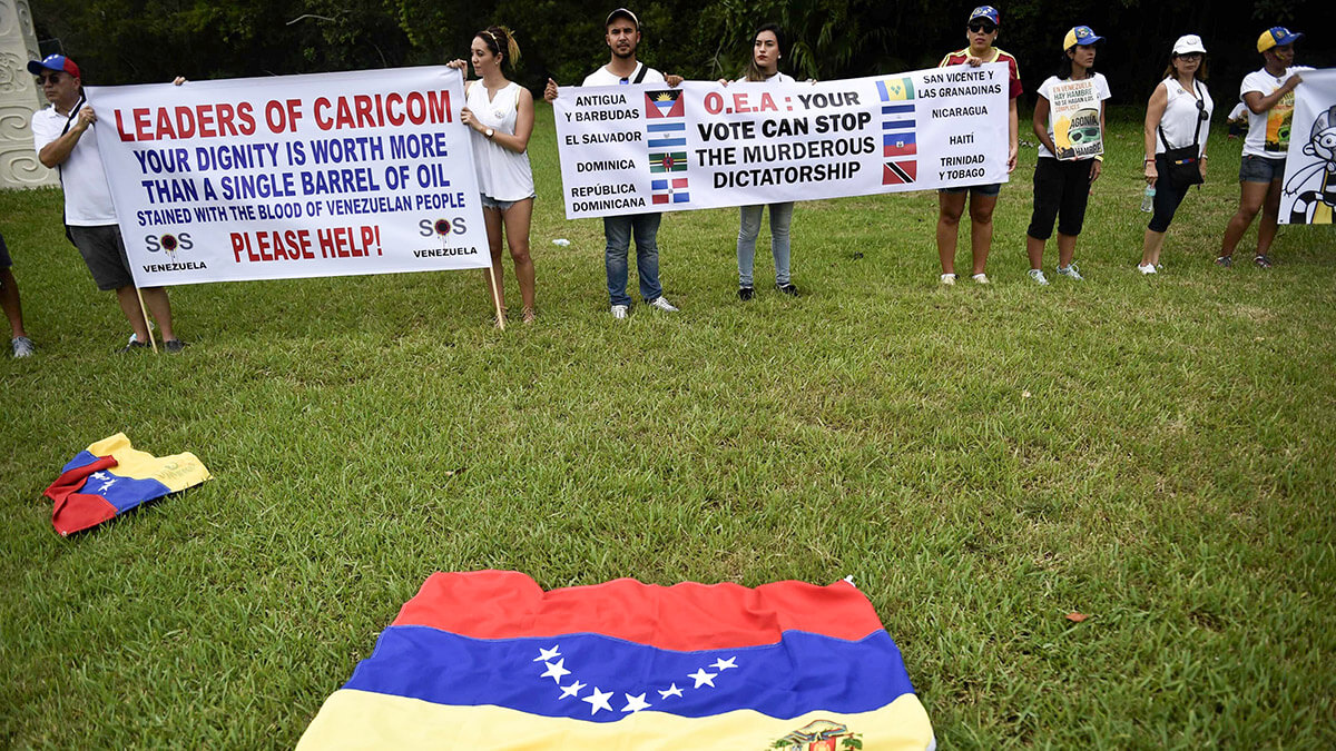 <p>Miembros de la comunidad venezolana en México en una protesta contra el Gobierno venezolano en vísperas de la apertura de la 47ª Asamblea General de la Organización de los Estados Americanos (OEA), cerca del aeropuerto internacional de Cancún, México el 18 de junio de 2017 - AFP/PEDRO PARDO </p>