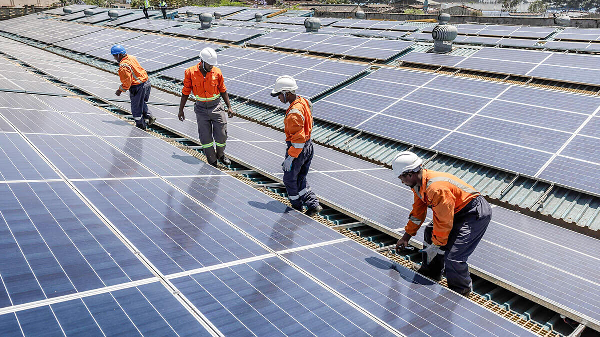 <p>Técnicos de CP Solar caminan sobre un tejado mientras trabajan en el mantenimiento de paneles solares en una fábrica que funciona parcialmente con energía solar en la zona industrial de Nairobi - AFP/ LUIS TATO </p>