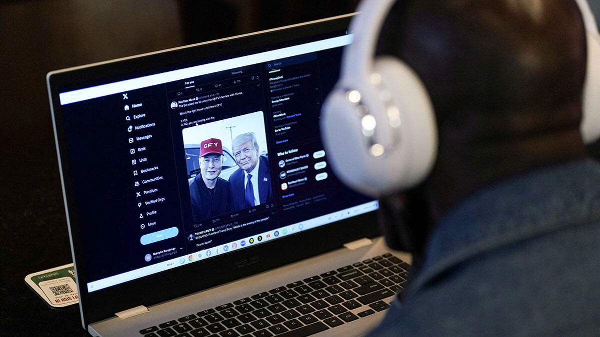 Una persona ve en una computadora portátil la entrevista del empresario multimillonario Elon Musk con el candidato presidencial republicano y expresidente estadounidense Donald Trump en la red social X - REUTERS/ADAM GRAY