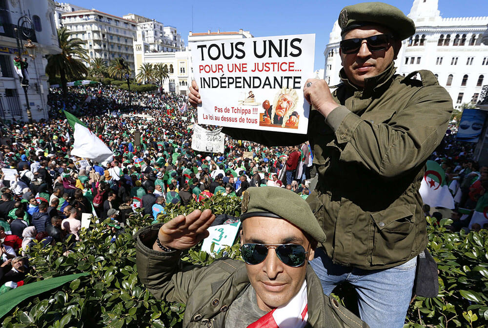 Un veterano de la guerra civil argelina sostiene un cartel que dice "Todos unidos por una justicia independiente" durante una protesta en Argel, Argelia, el 29 de marzo de 2019 - PHOTO/AP