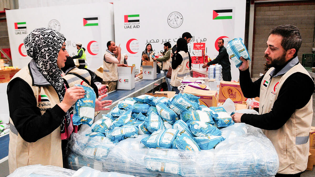 Voluntarios de la Media Luna Roja de los Emiratos preparan paquetes con ayuda humanitaria para Gaza que se transferirán a través del cruce fronterizo de Rafah entre Egipto y la Franja de Gaza, en El Cairo - PHOTO/REUTERS