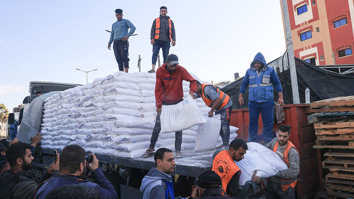 Los palestinos reciben bolsas de harina en el centro de distribución del Organismo de Obras Públicas y Socorro de las Naciones Unidas para los Refugiados de Palestina (UNRWA) en el campo de refugiados de Rafah -
AFP/ SAID KHATIB