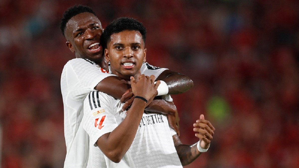 El delantero brasileño del Real Madrid Rodrygo celebra la anotación del primer gol de su equipo con el delantero brasileño del Real Madrid Vinicius Junior durante el partido de fútbol de la Liga española entre el RCD Mallorca y el Real Madrid CF en el estadio Mallorca Son Moix en Palma de Mallorca el 18 de agosto de 2024 – PHOTO/JAIME REINA/AFP