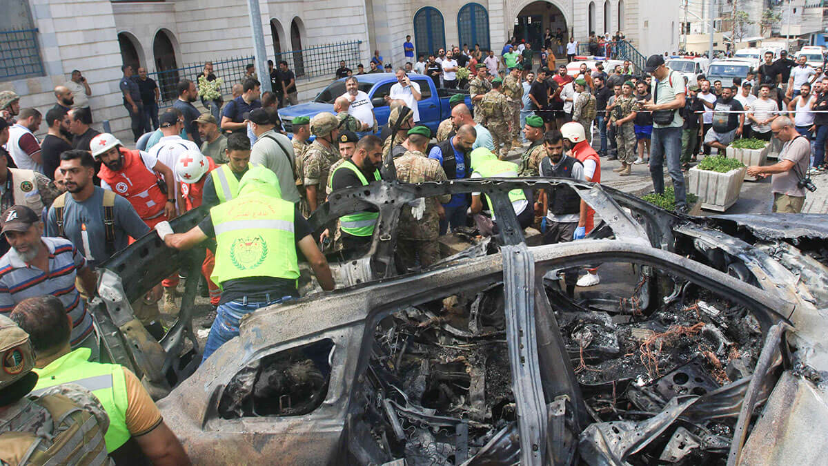 La defensa civil libanesa inspecciona un automóvil que fue blanco de un ataque israelí en la ciudad de Sidón, al sur del Líbano, el 21 de agosto de 2024 - AFP/MAHMOUD ZAYTYAT