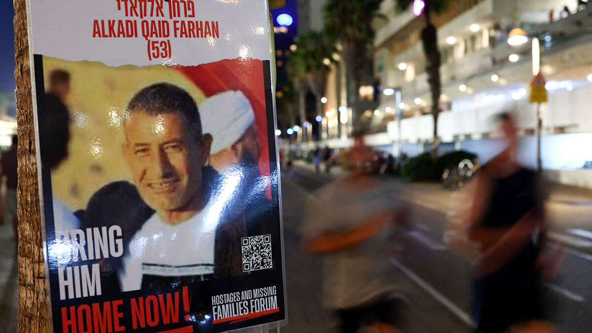 Cartel de Qaid Farhan Alkadi, un rehén israelí beduino que fue secuestrado en el mortal ataque de Hamas del 7 de octubre y luego rescatado por fuerzas israelíes, se exhibe en la calle en Tel Aviv - REUTERS/ FLORION GOGA