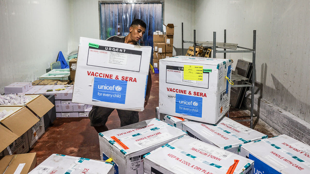 Un trabajador descarga un cargamento de vacunas antipoliomielíticas suministradas con ayuda de UNICEF a la Franja de Gaza a través del paso fronterizo de Karm Abu Salem - AFP/ EYAD BABA