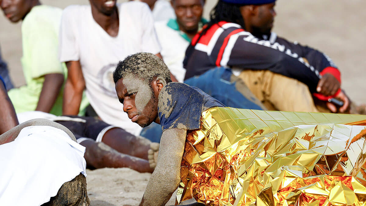 <p>Un grupo de migrantes descansa en la arena tras llegar en una patera de fibra a la playa de Las Burras en San Agustín, en la isla de Gran Canaria, España, el 19 de julio de 2024 - REUTERS/BORJA SUÁREZ </p>
