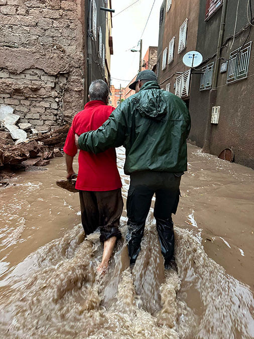 <p>Miembros de las Fuerzas Auxiliares de Marruecos ayudan a evacuar a personas de un barrio inundado en la ciudad de Ouarzazate - AFP/ABDERAHIM ELBCIR</p>