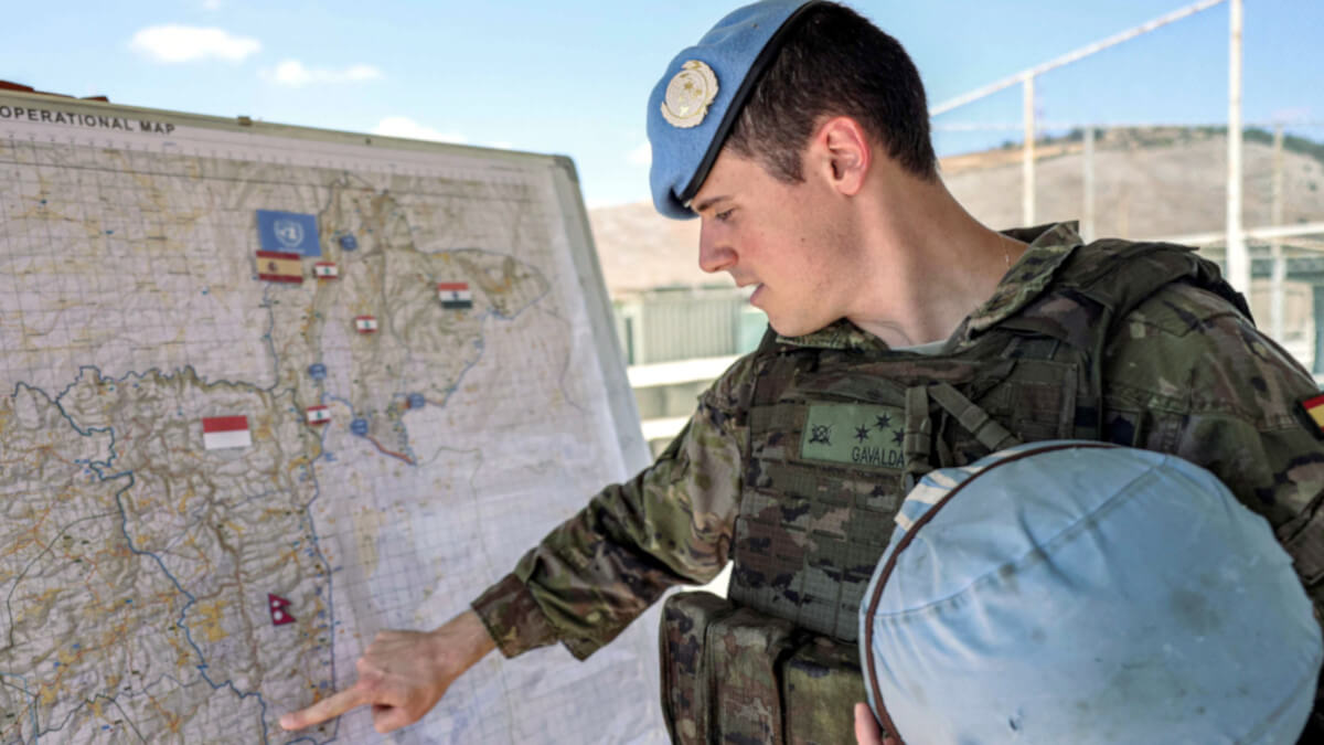 Un soldado de paz del contingente español señala un mapa que muestra las ubicaciones de despliegue de otros contingentes de la Fuerza Provisional de las Naciones Unidas en el Líbano (FPNUL), en sus cuarteles cerca de Khiam en el sur del Líbano el 23 de agosto de 2024 - PHOTO / ANWAR AMRO / AFP