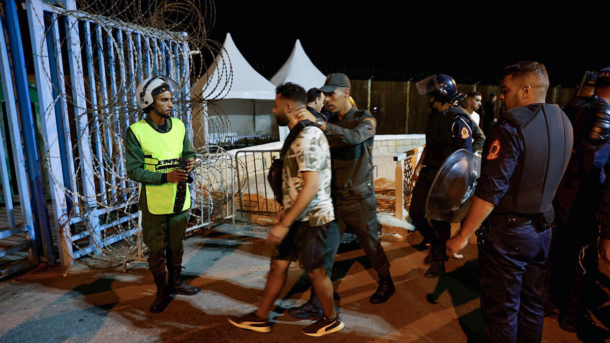 <p>Miembros de las Fuerzas Auxiliares de Marruecos arrestan a un hombre mientras se despliegan para evitar cruces ilegales de la valla fronteriza terrestre con el enclave africano español de Ceuta, cerca de Fnideq en el norte de Marruecos el 15 de septiembre de 2024 - PHOTO/ AFP </p>