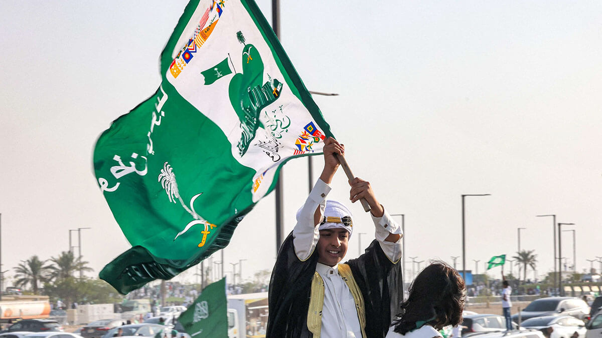 Un niño ondea una bandera mientras asiste a un espectáculo aéreo que marca las celebraciones del 93.º Día Nacional de Arabia Saudita en Riad el 23 de septiembre de 2023 - AFP/ FAYEZ NURELDINE