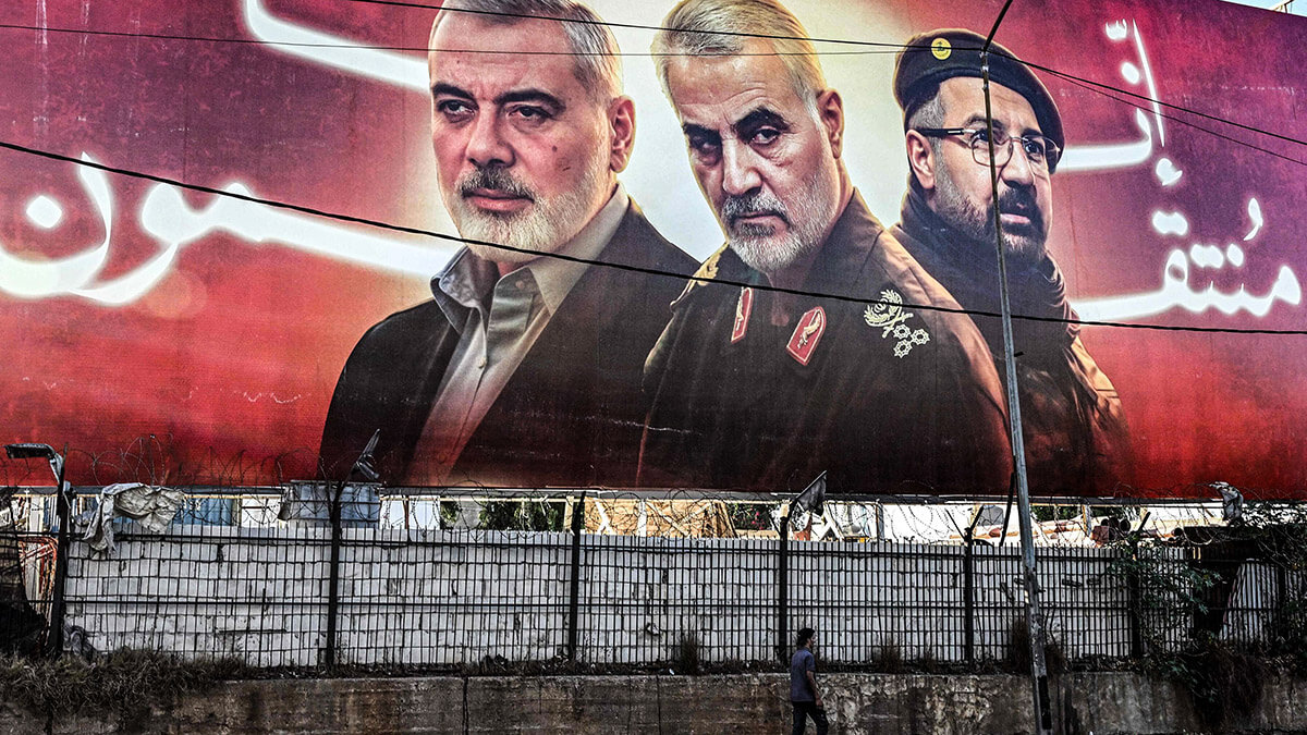<p>Cartel que muestra imágenes de las figuras asesinadas (de izq. a der.) el líder político palestino de Hamás, Ismail Haniyeh, el comandante de la Fuerza Quds del Cuerpo de la Guardia Revolucionaria Islámica (CGRI) de Irán, Qasem Soleimani, y el comandante del Hezbolá libanés, Fuak Shukr, a lo largo de una carretera que conduce al Aeropuerto Internacional de Beirut, el 19 de septiembre de 2024 - AFP/JOSEPH EID  </p>
