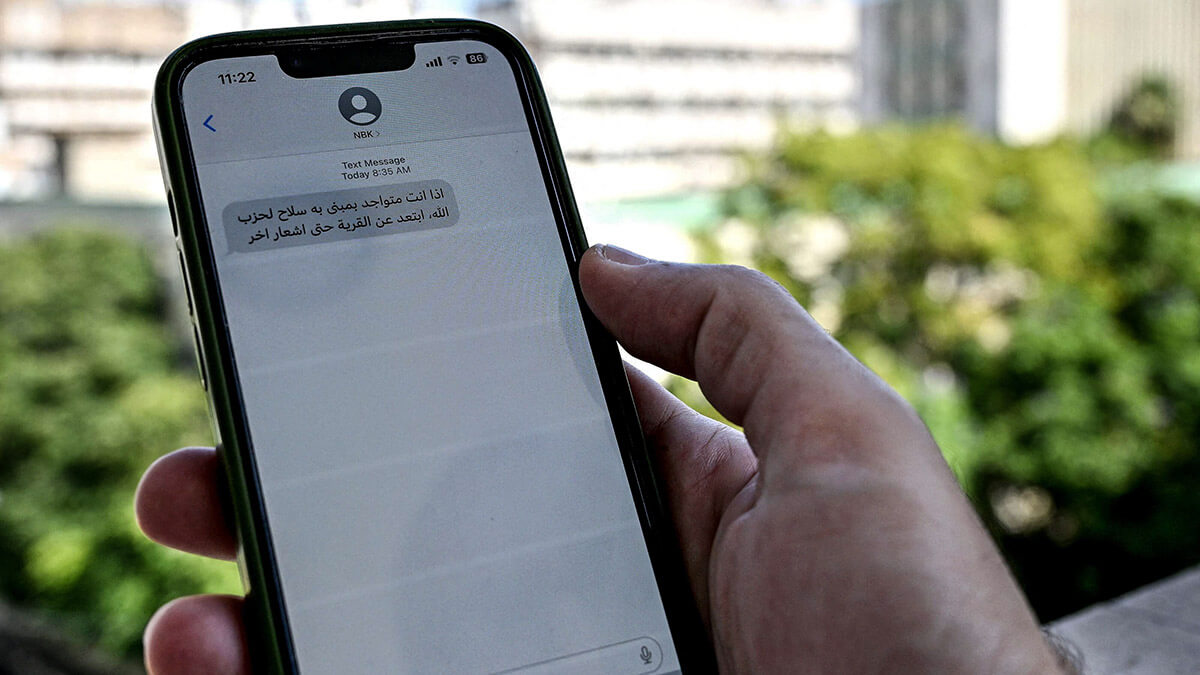 Un libanés revisa un mensaje recibido en su teléfono móvil en Beirut el 23 de septiembre de 2024, llamando a la gente a evacuar las áreas donde Hezbollah esconde sus armas - AFP/ JOSEPH EID