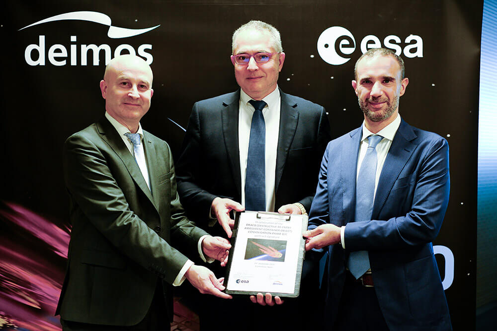 Holger Krag (ESA), Juan Carlos Cortés (AEE) y Simone Centuori (Deimos) muestran el contrato por el que Deimos es el contratista principal del desarrollo e integración de DRACO y del segmento terreno - PHOTO/Deimos Space